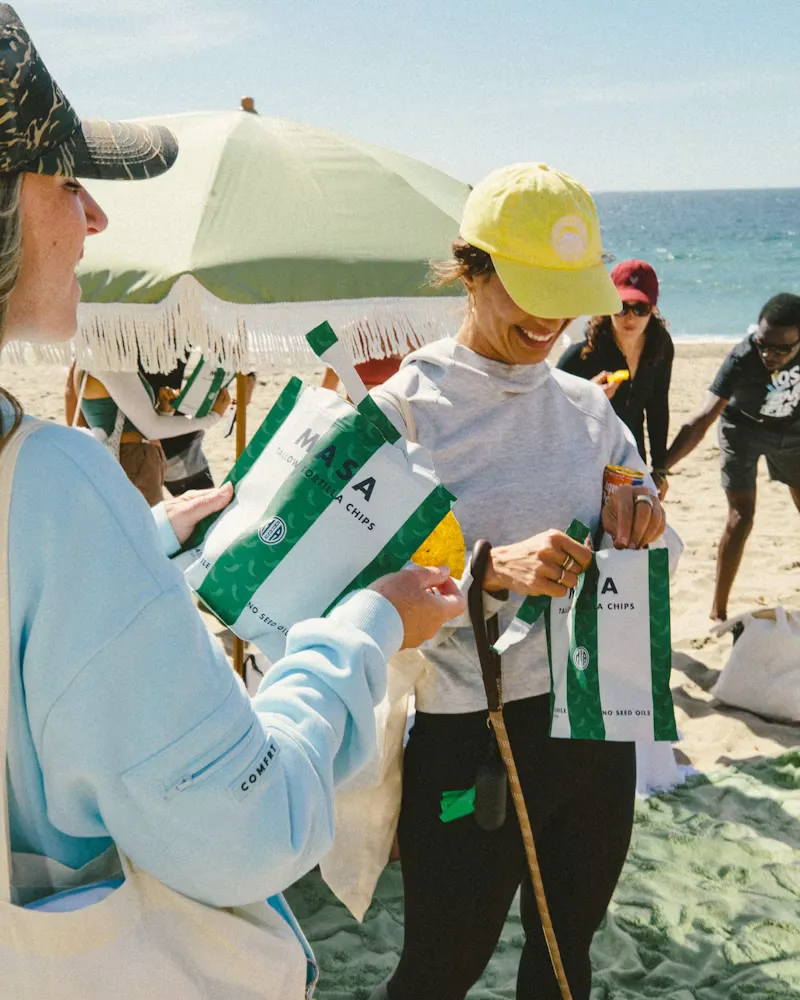 A host handing out drinks at a beach event