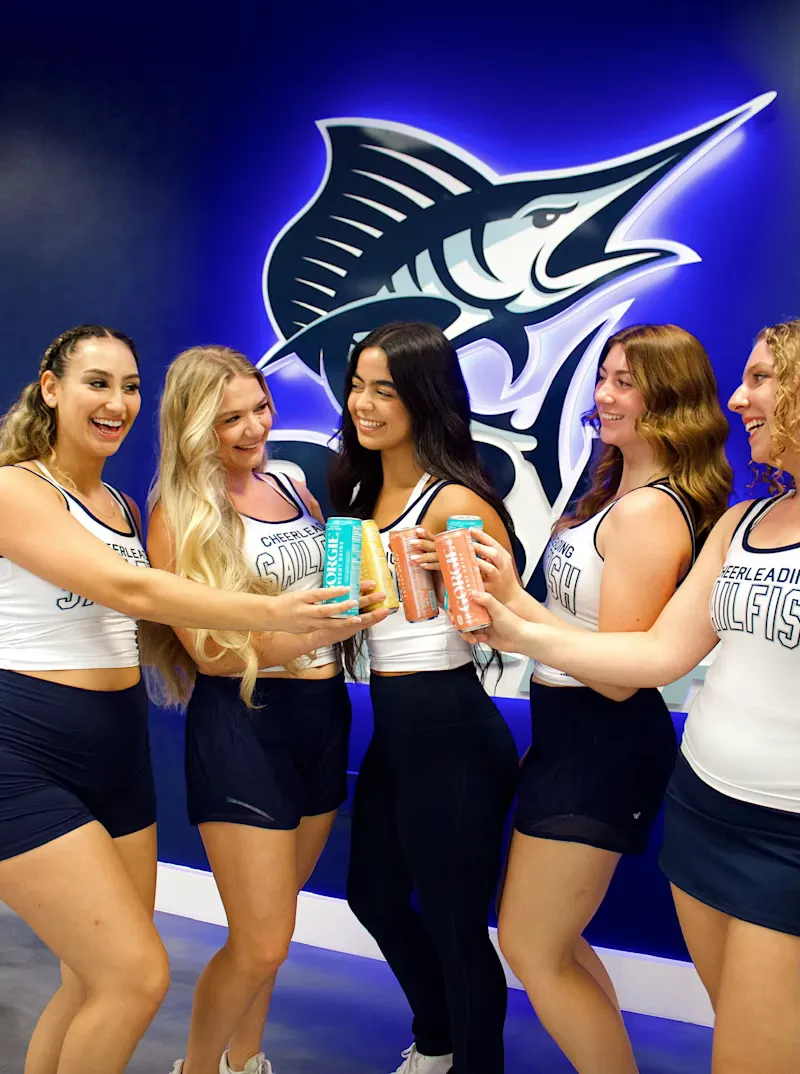 A dance team with drinks at a game-day event