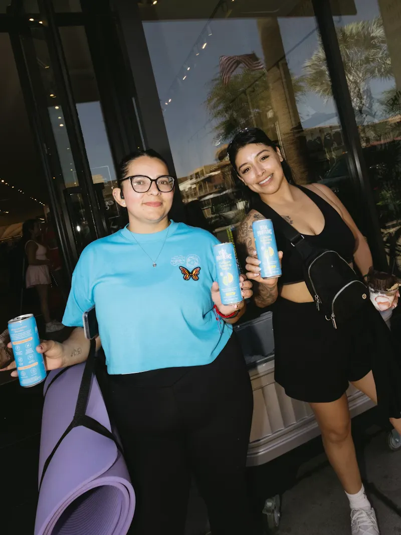 Two guests with mats outside a studio event
