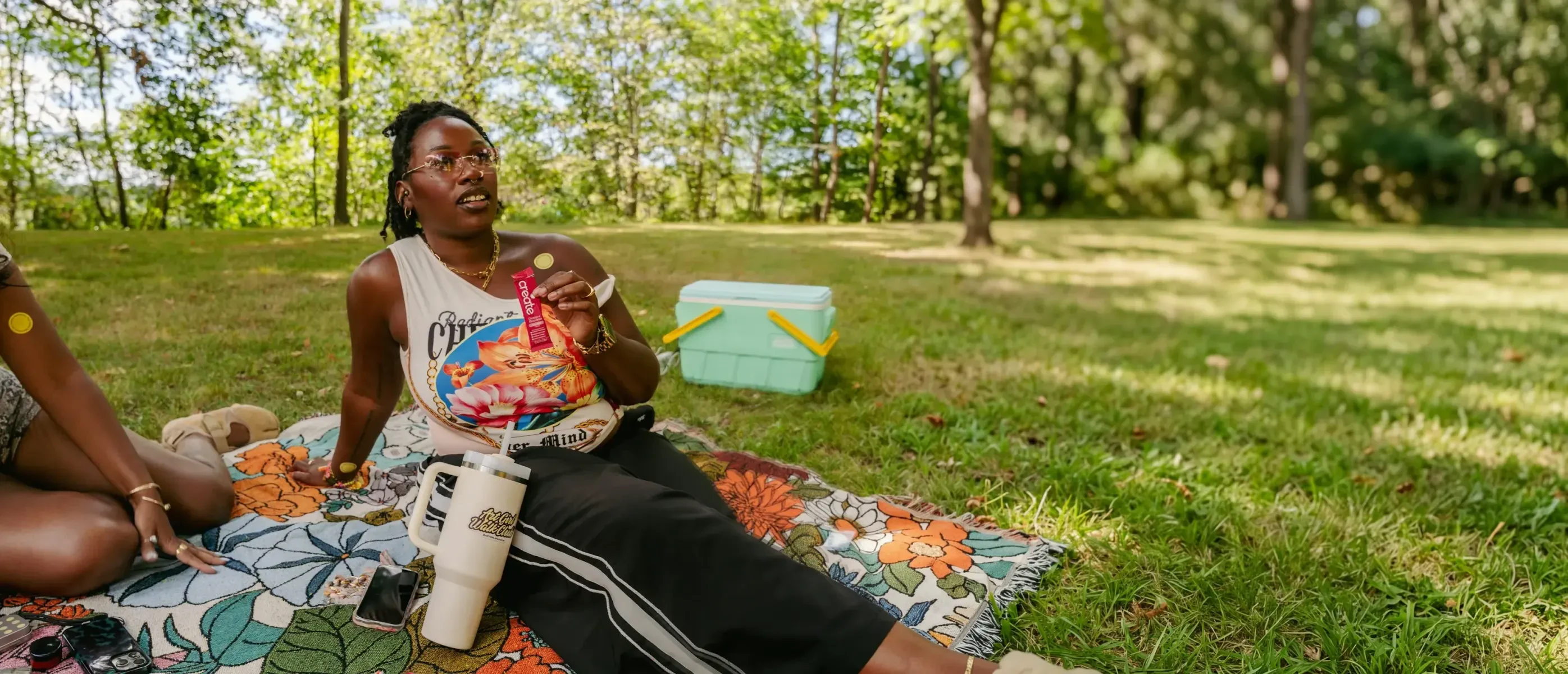 A host at a park picnic holding a Create creatine stick